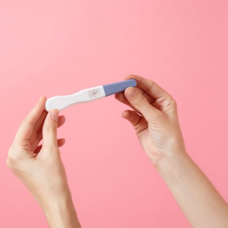 weibliche Hände halten Schwangerschaftstest