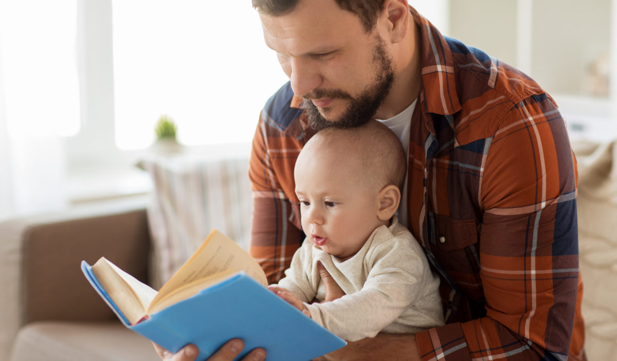 Vater liest mit Baby in einem Buch