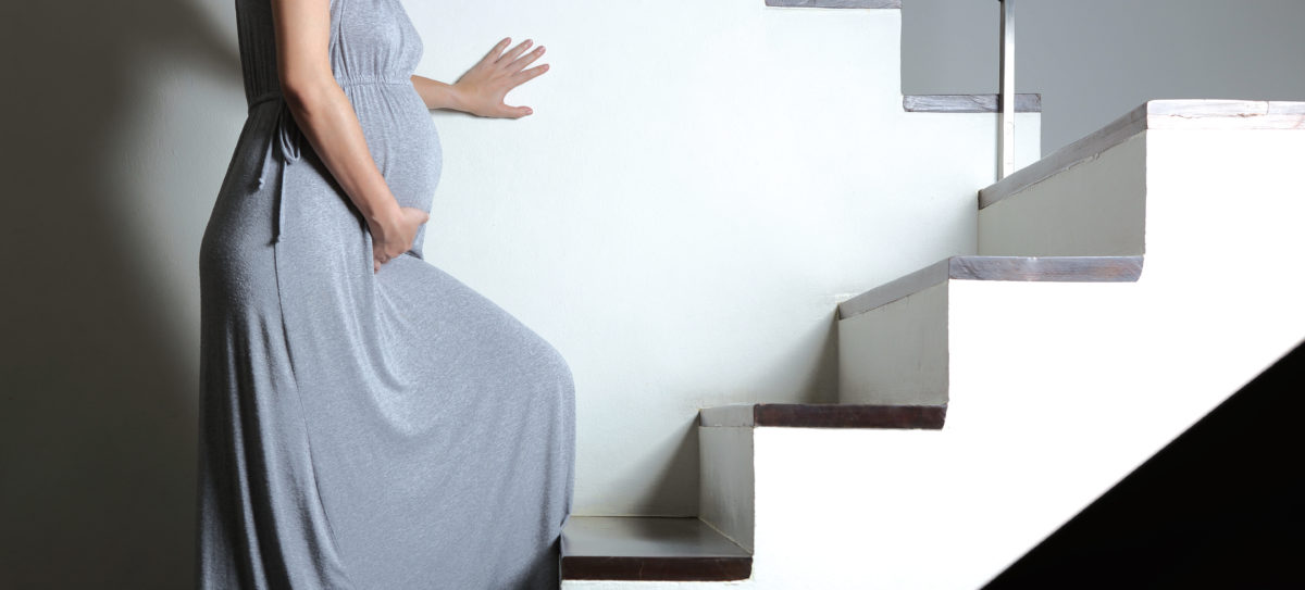 Schwangere Frau geht eine Treppe hoch