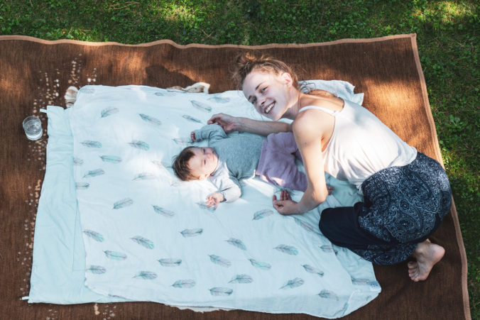 Kind mit Baby auf Decke