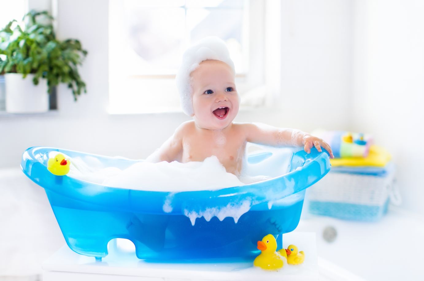 Baby in Badewanne mit Quietsche-Entchen