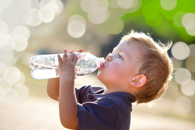 Kleiner Junge trinkt aus Wasserflasche