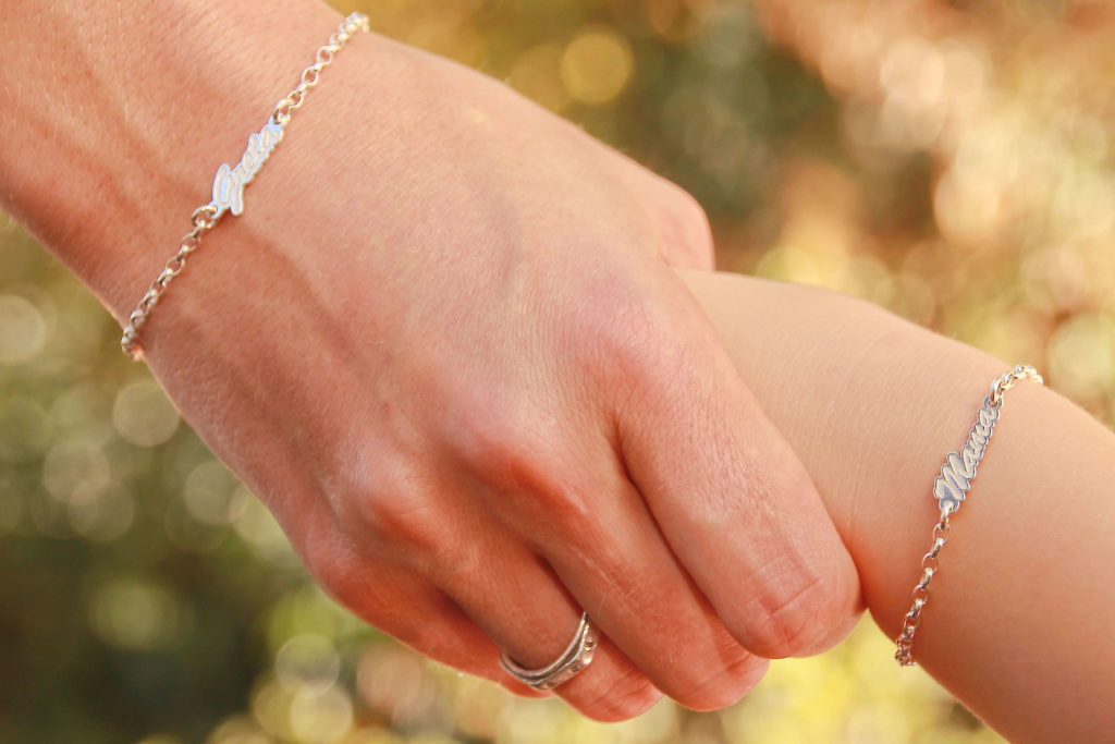 Mutter und Tochter mit Armband Hand in Hand