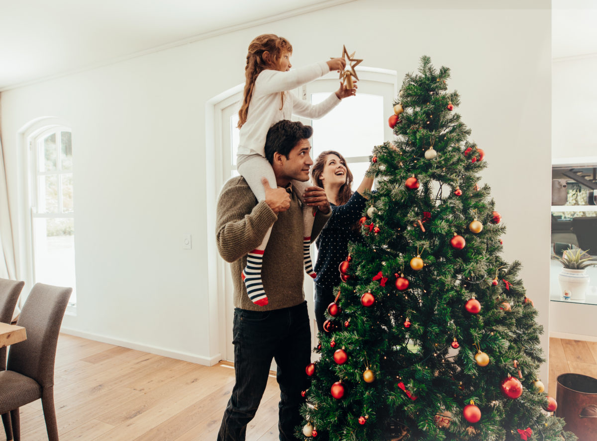 Familie schmückt Weihnachtsbaum