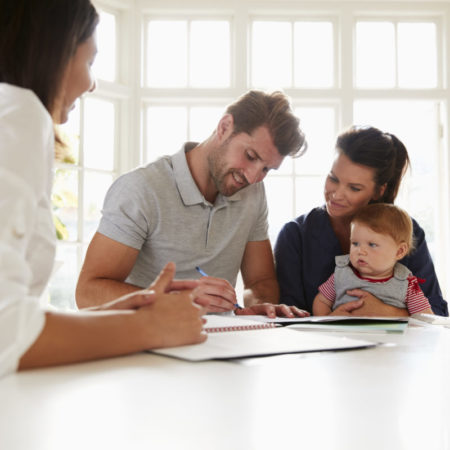 Familie mit Baby informiert sich über wichtige Versicherungen