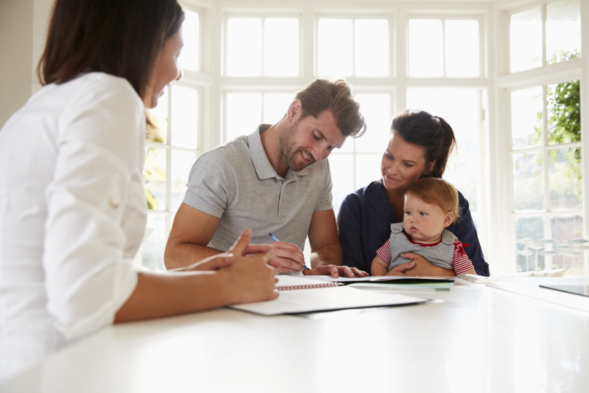 Familie mit Baby informiert sich über wichtige Versicherungen