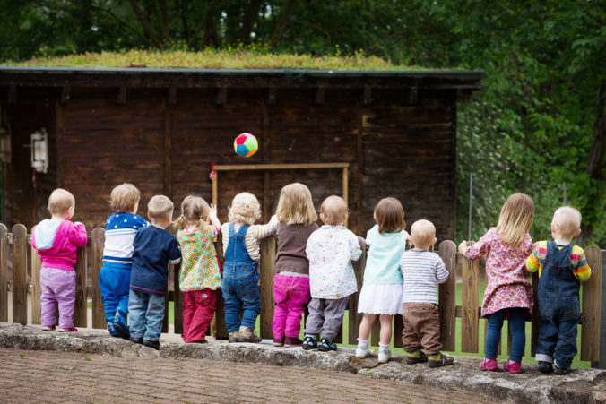 Kinder stehen am Zaun