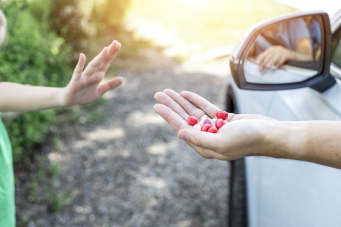 Fremder Mann bietet Kind Süßigkeiten aus dem Auto heraus an