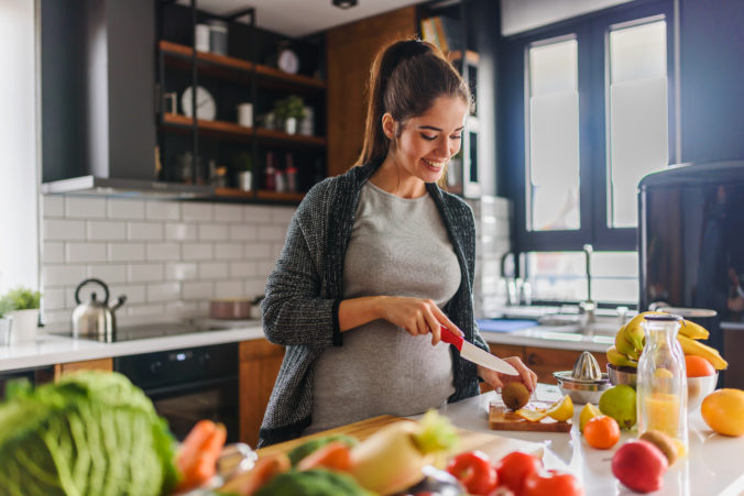 Schwangere Frau bereitet sich gesundes Essen vor