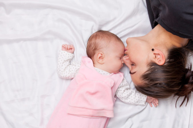 Mama küsst Baby auf die Stirn