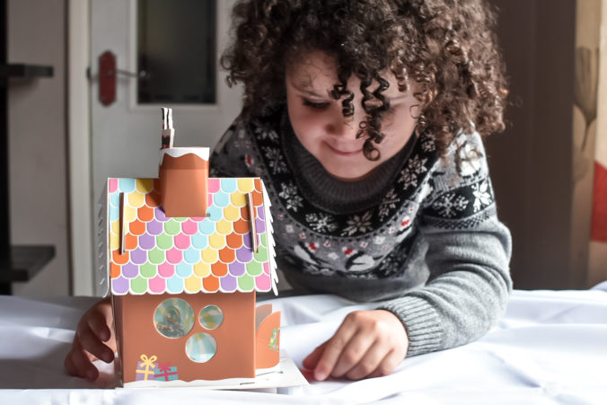 Mädchen bastelt Lebkuchenhaus