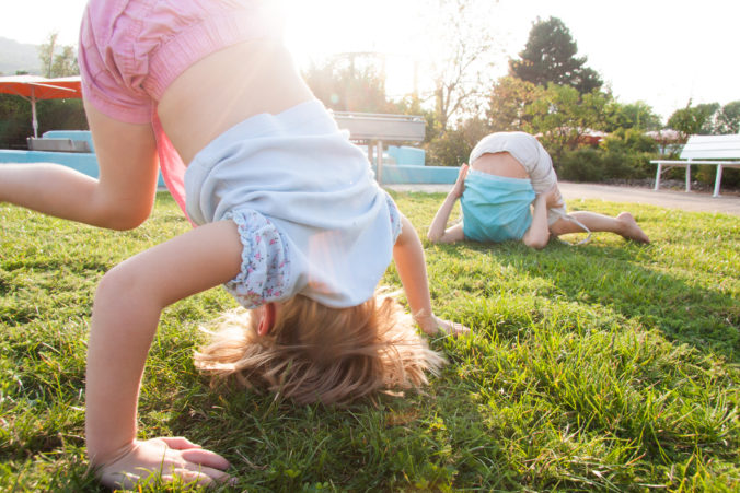 Kinder machen Purzelbäume im Garten