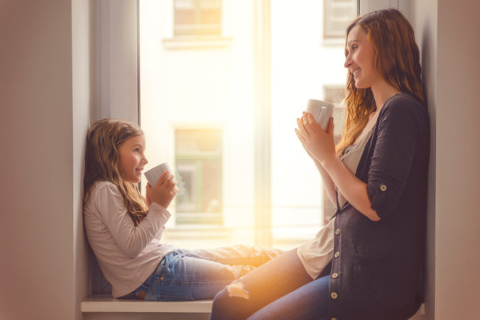 Mama und Kind reden am Fenster