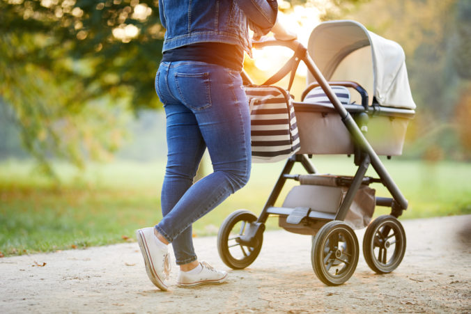 Frau schiebt Kinderwagen