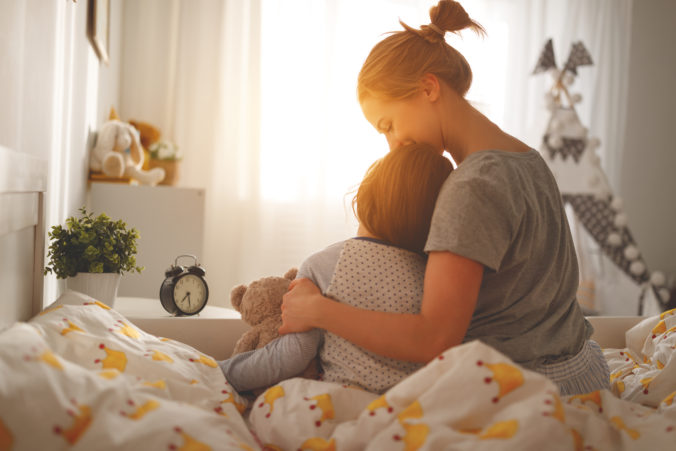 Mama und kleiner Sohn sitzen auf dem Bett