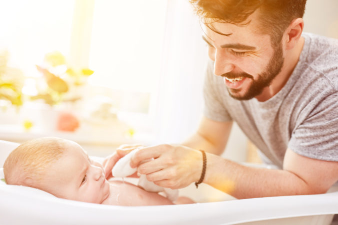 Mann trocknet Baby mit Waschlappen