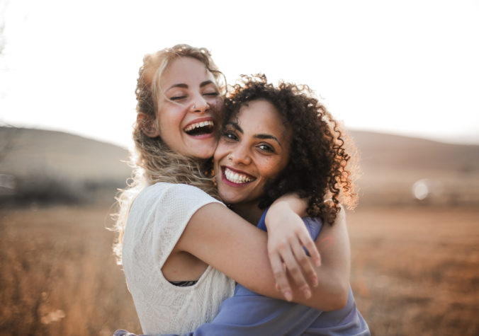 Zwei Frauen umarmen sich und lachen