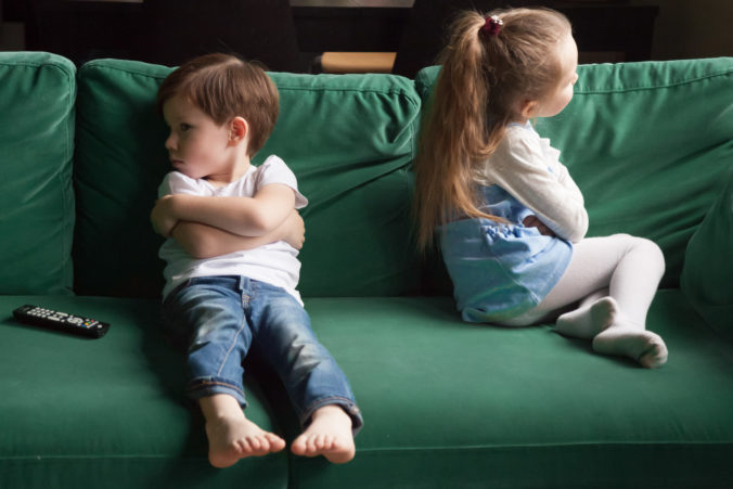 Zwei beleidigte Kinder sitzen auf dem Sofa