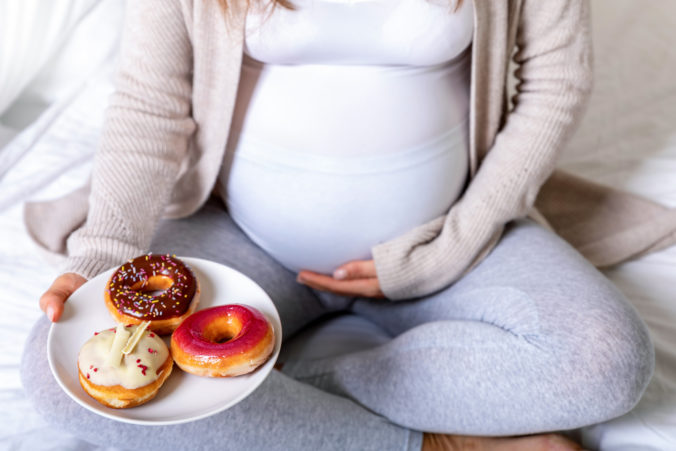 Schwangere Frau mit Donuts