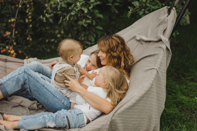 Mama und Kinder liegen zusammen in der Hängematte