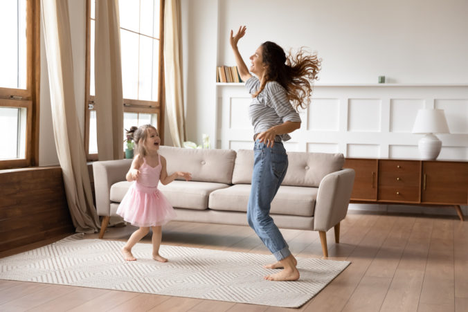 Kind und Mama tanzen im Wohnzimmer