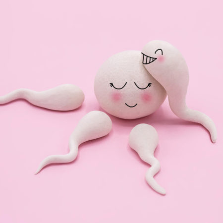 Weiße Spermien vor rosa Hintergrund