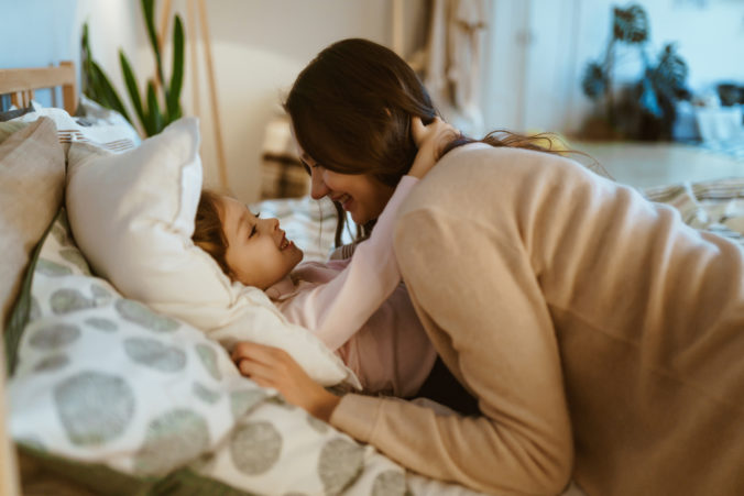 Mutter kuschelt mit Kind im Bett