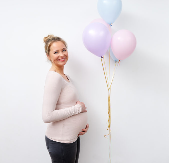 Schwangere Frau mit Luftballons