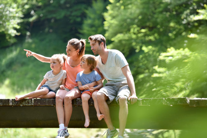 Familie sitzt auf einer Brücke