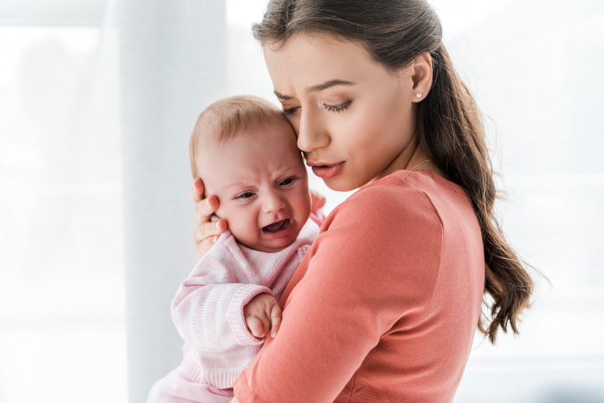 Baby auf Mamas Arm am weinen